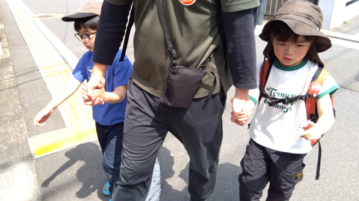 保育者と手をつなぎ歩く子どもたち