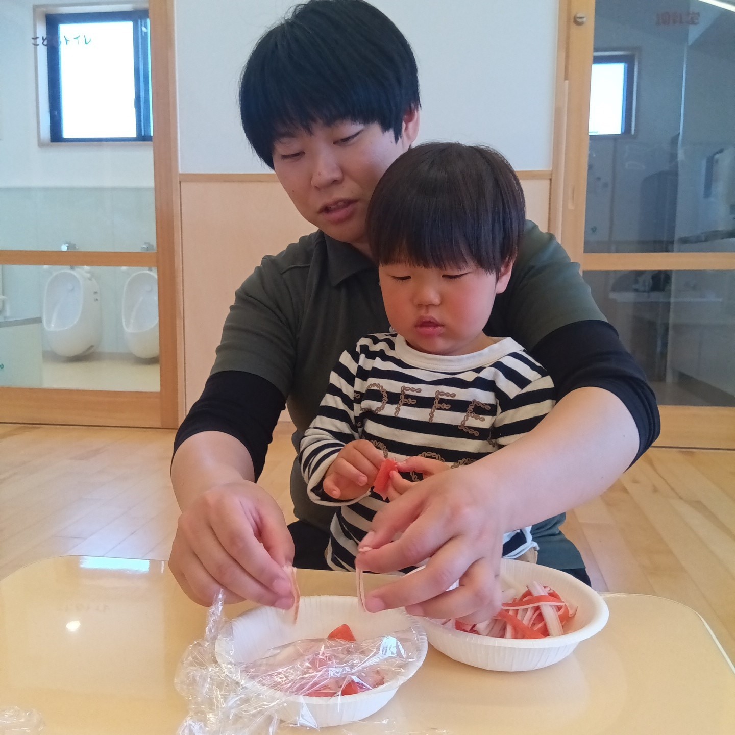 太巻き用のカニカマを割く子ども