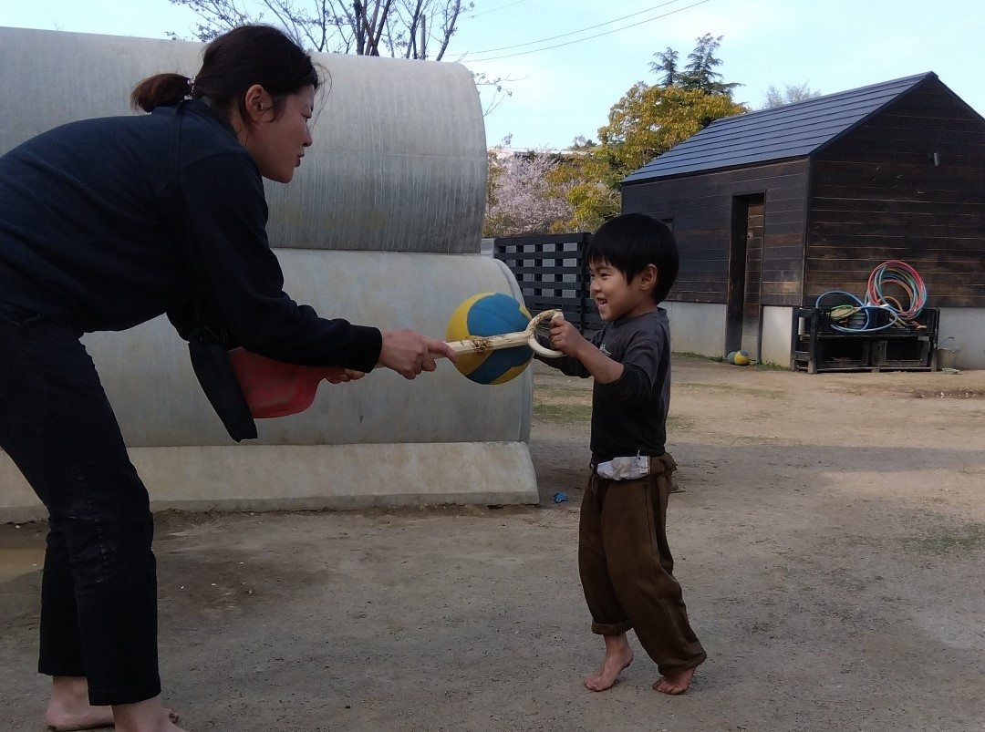 ボール運びをする子どもとスタッフ