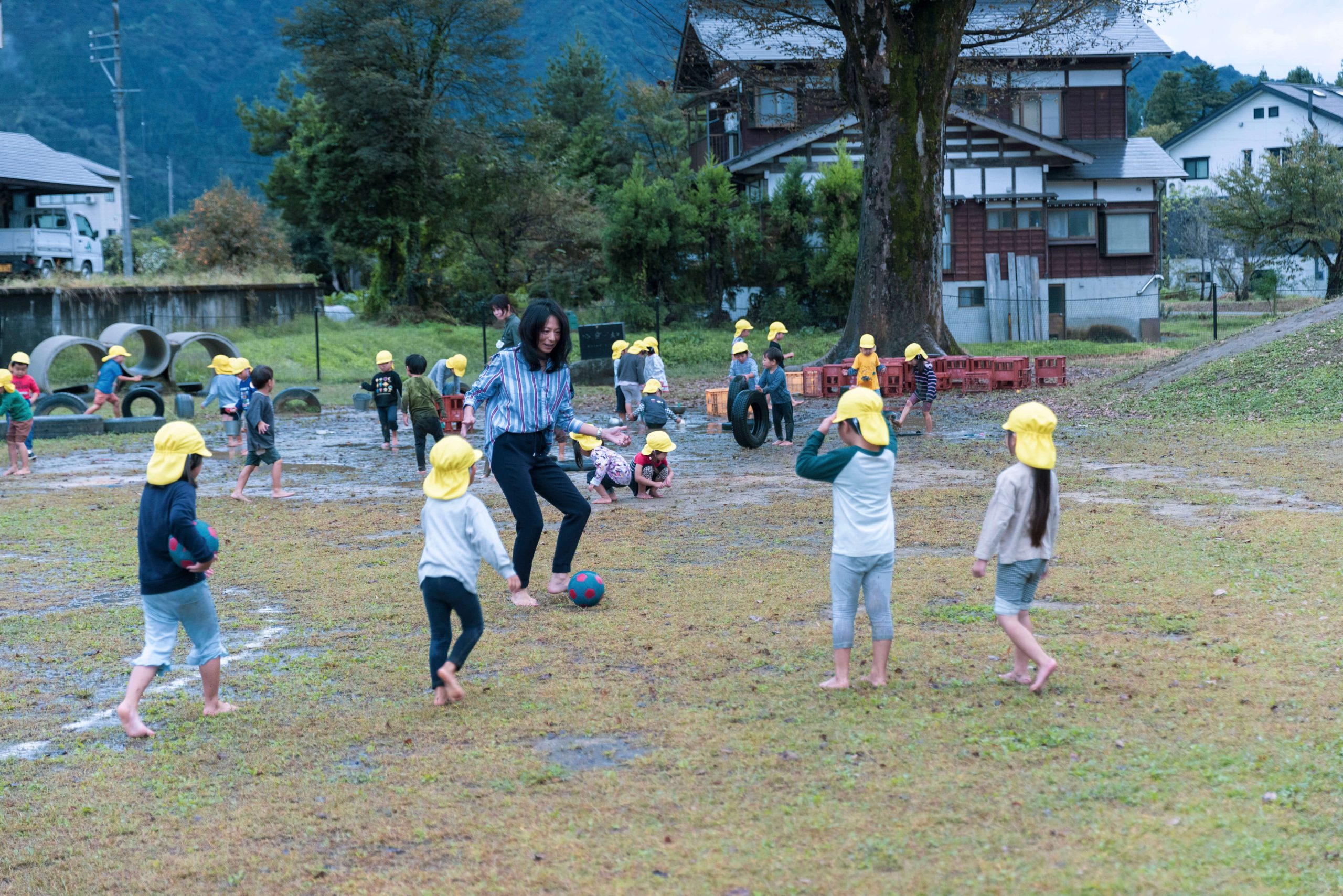 子どもたちと園庭でサッカーをする安永さん