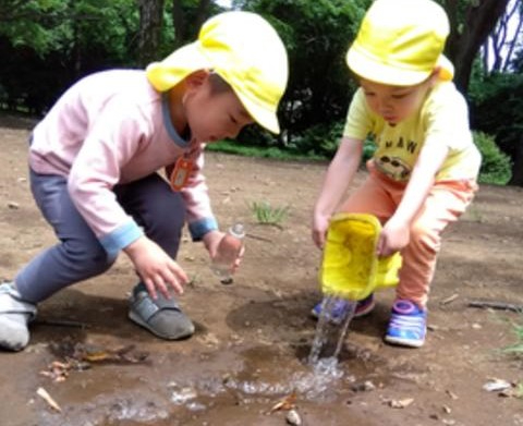 バケツの水を流す子ども