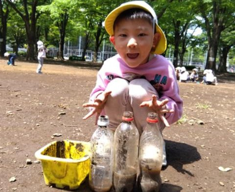 ペットボトルと桶を並べる子ども