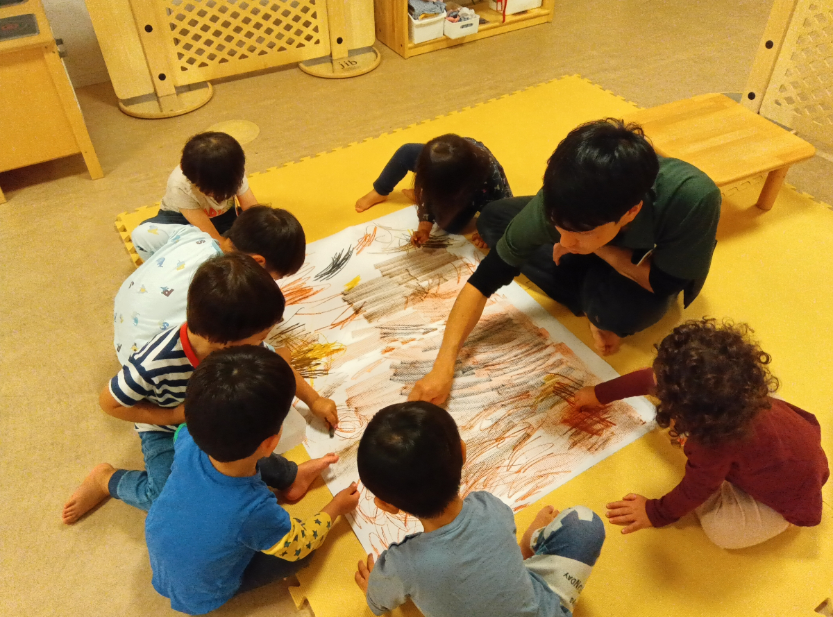 紙に色塗りをする子どもたちの様子