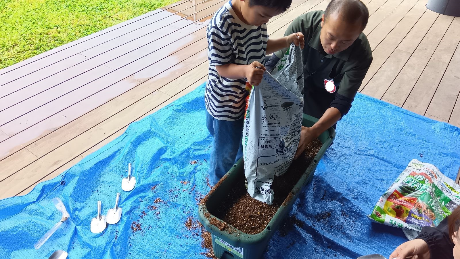 プランターに土を移し替える子ども
