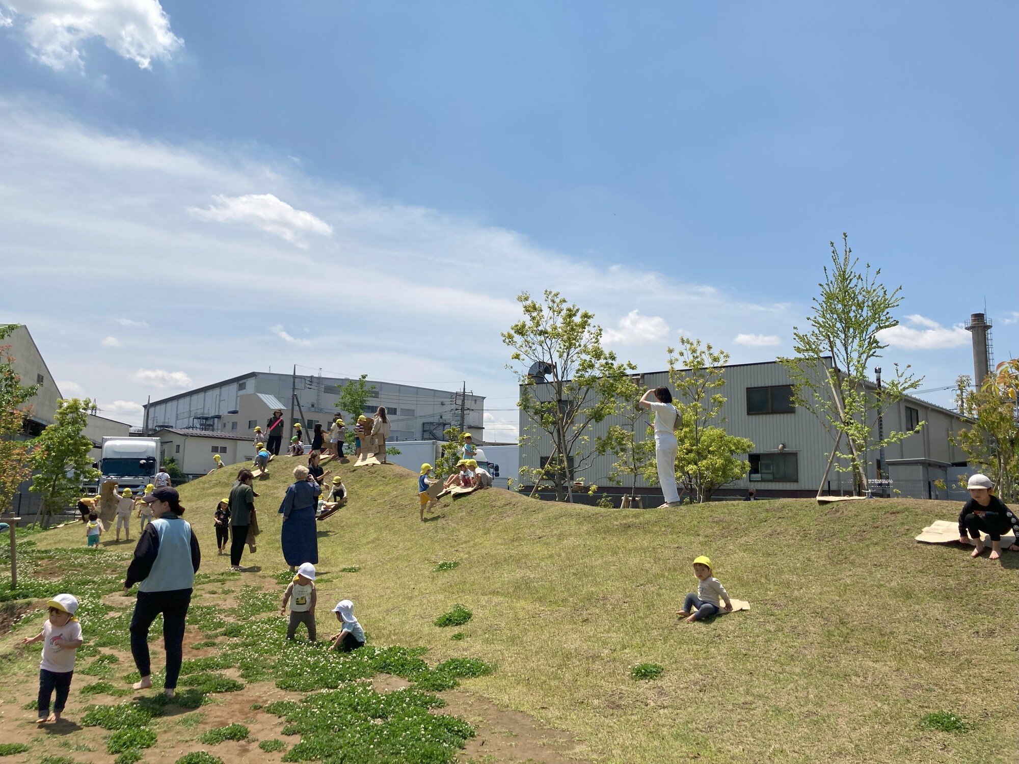 裸足で築山を登りながら、保育環境の魅力に触れる視察の参加者