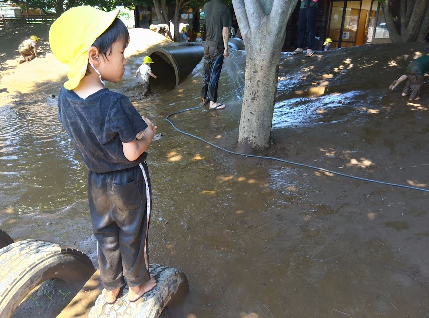 タイヤに登って友だちを眺める子ども
