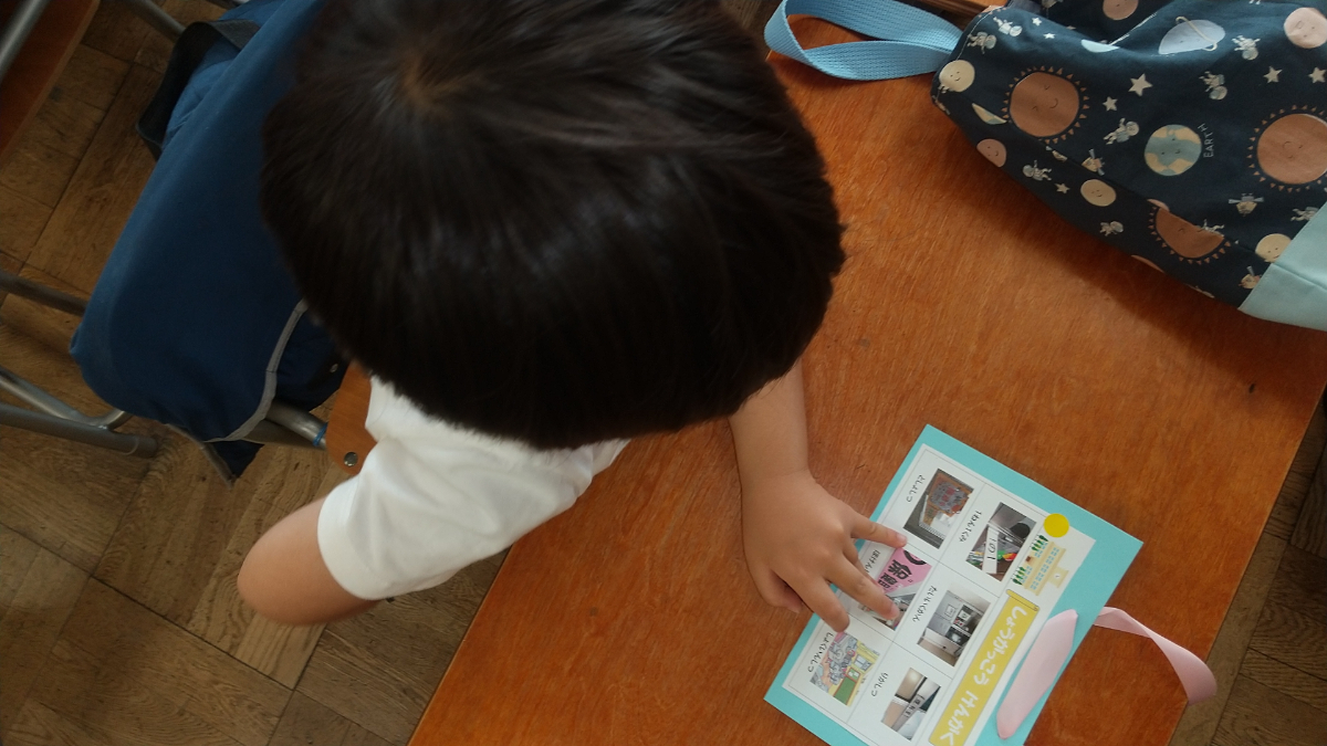 椅子に座ってカードを見る子ども
