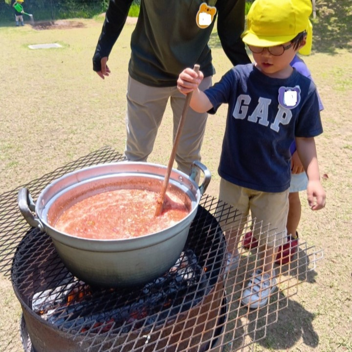 園庭でトマトスープを煮込む様子