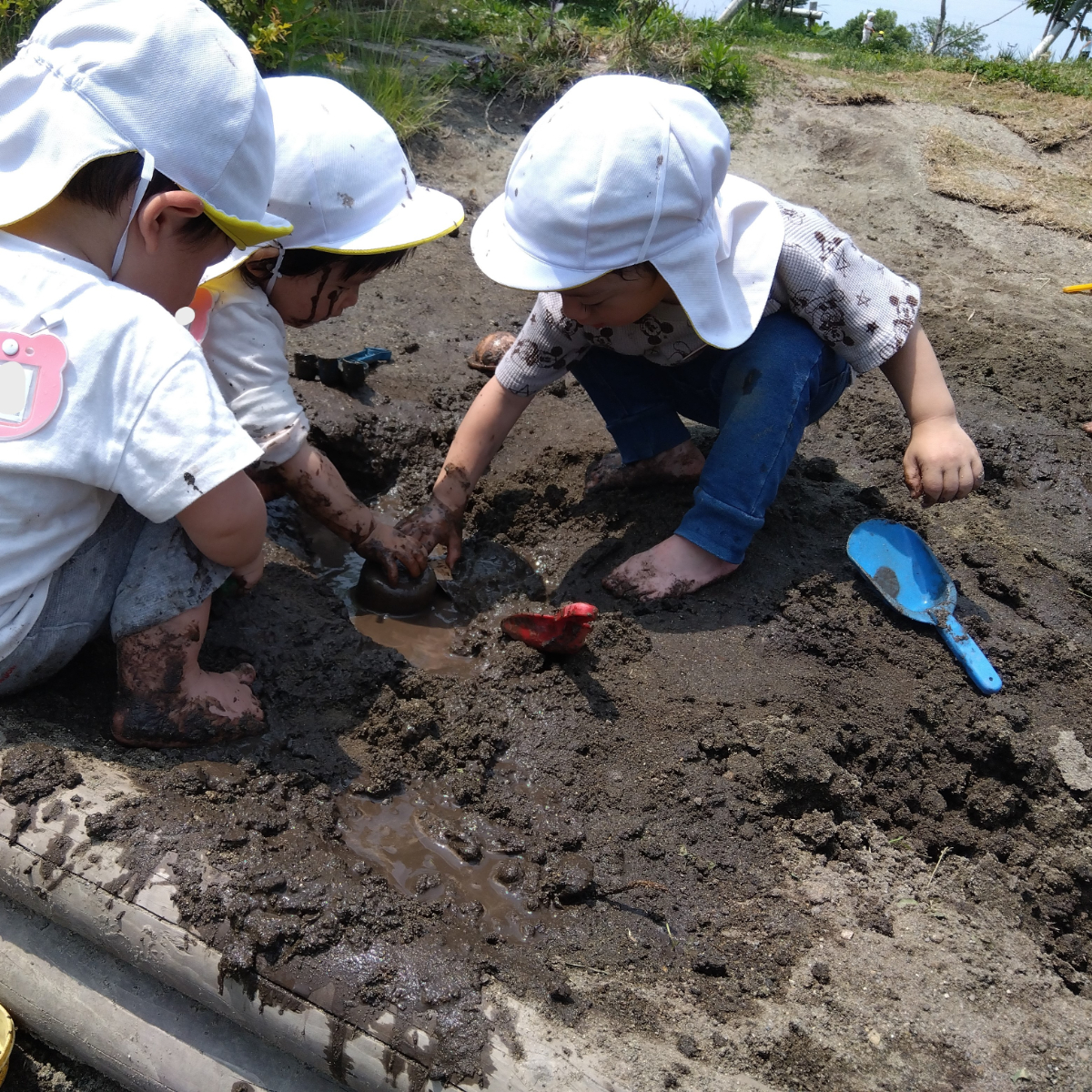 泥遊びをする子どもたち