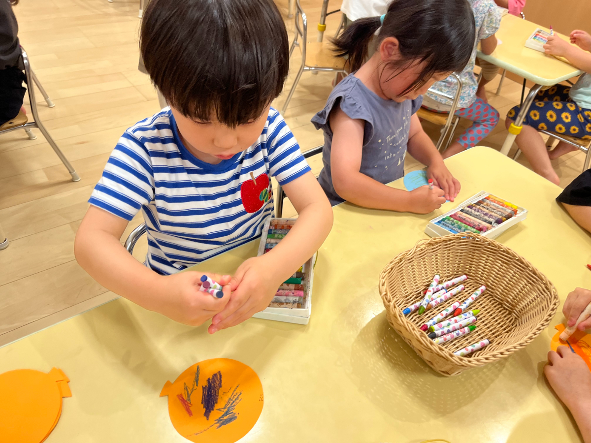 クレヨンで絵柄をつける子ども