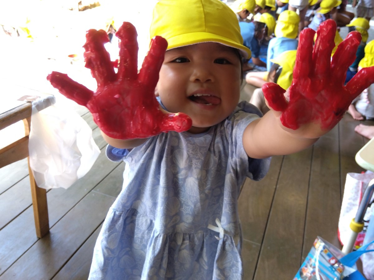 手に着いた絵の具を見せる子ども