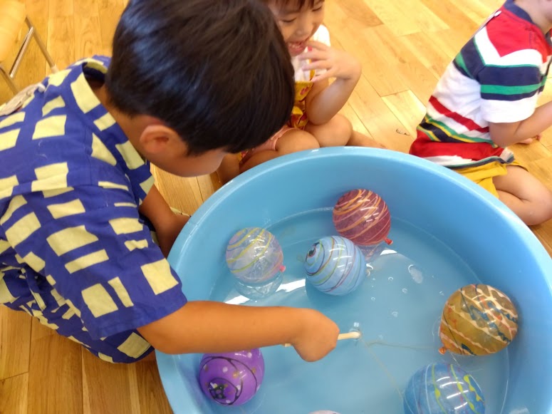 ヨーヨーすくいをする子ども