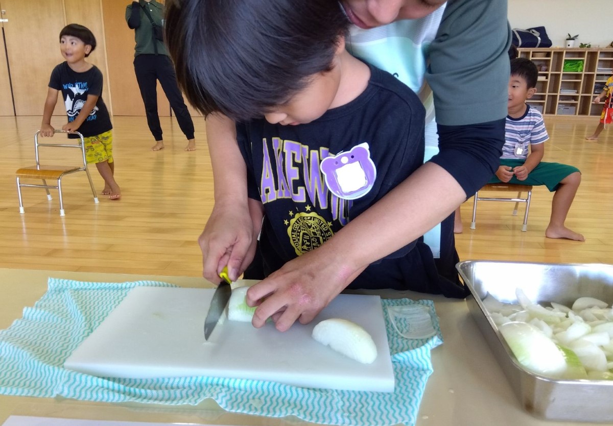 玉ねぎを包丁で切る子ども