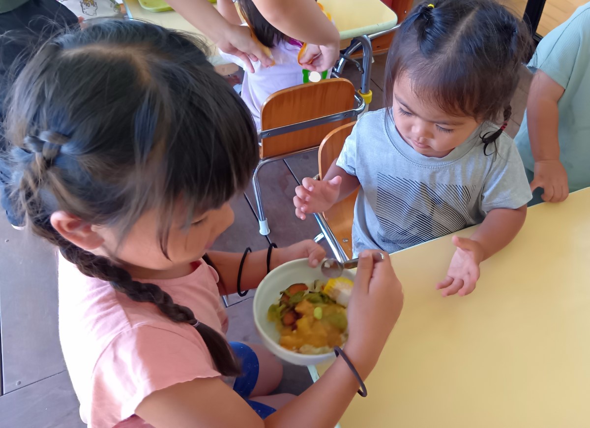 調理したカレーを食べる子ども