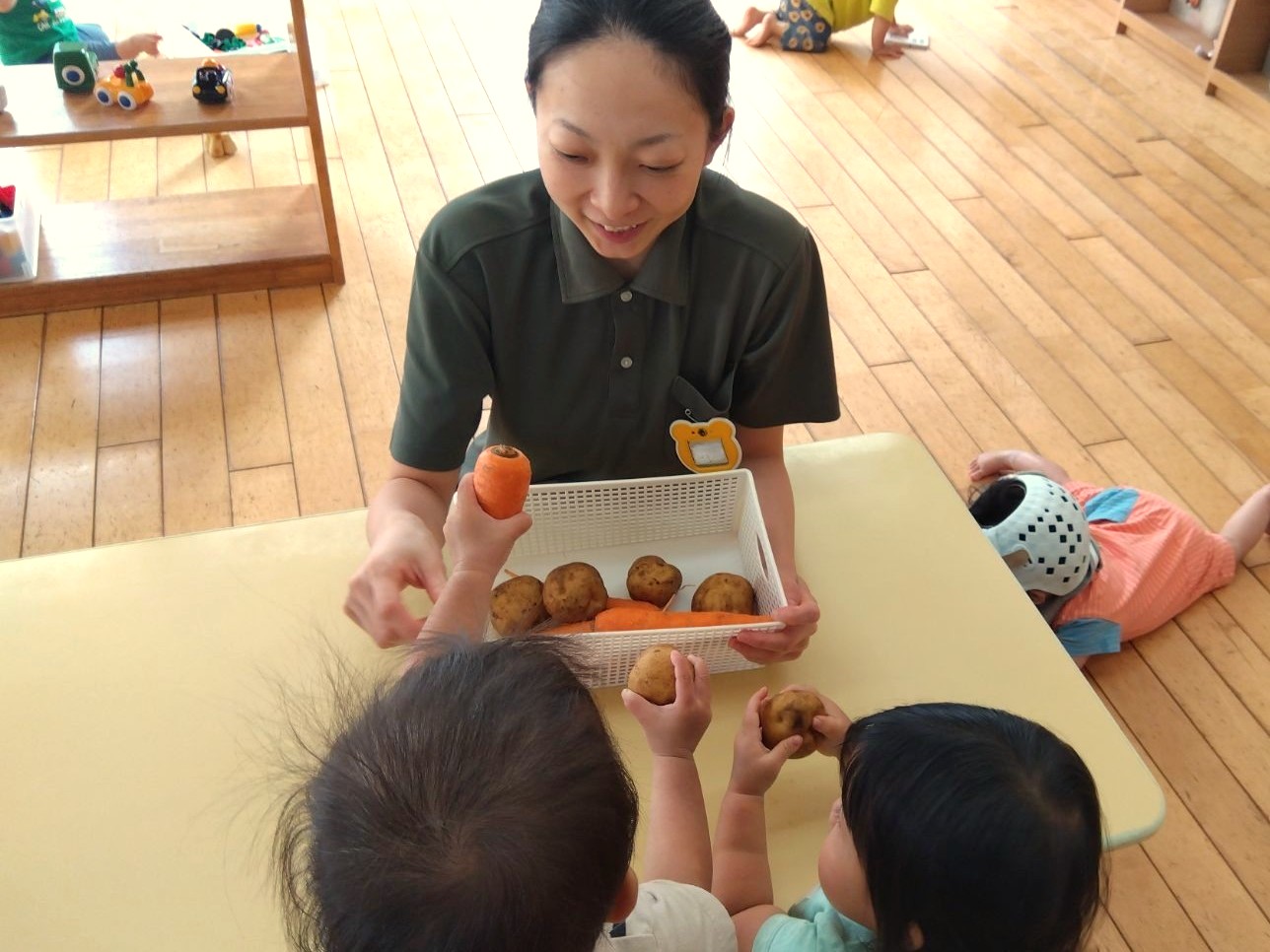 どろんこアグリの野菜を見比べる子どもたちと澤本さん