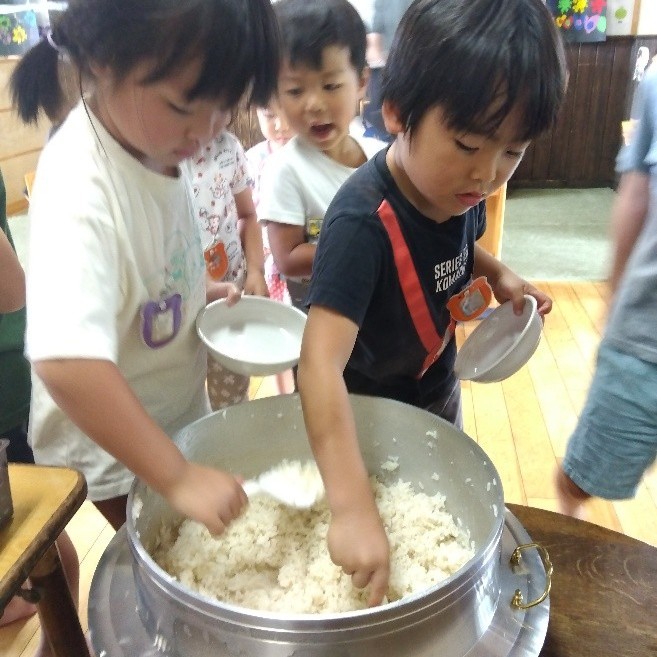 ご飯を茶碗によそう子どもたち