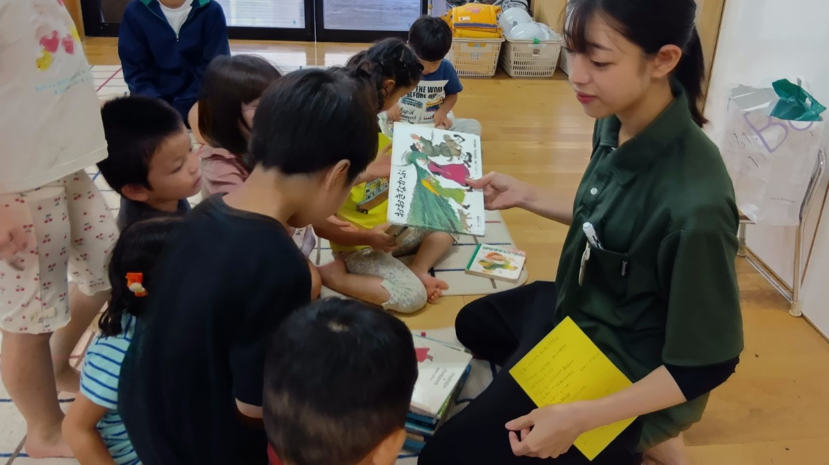 絵本の表紙を眺める子どもたち