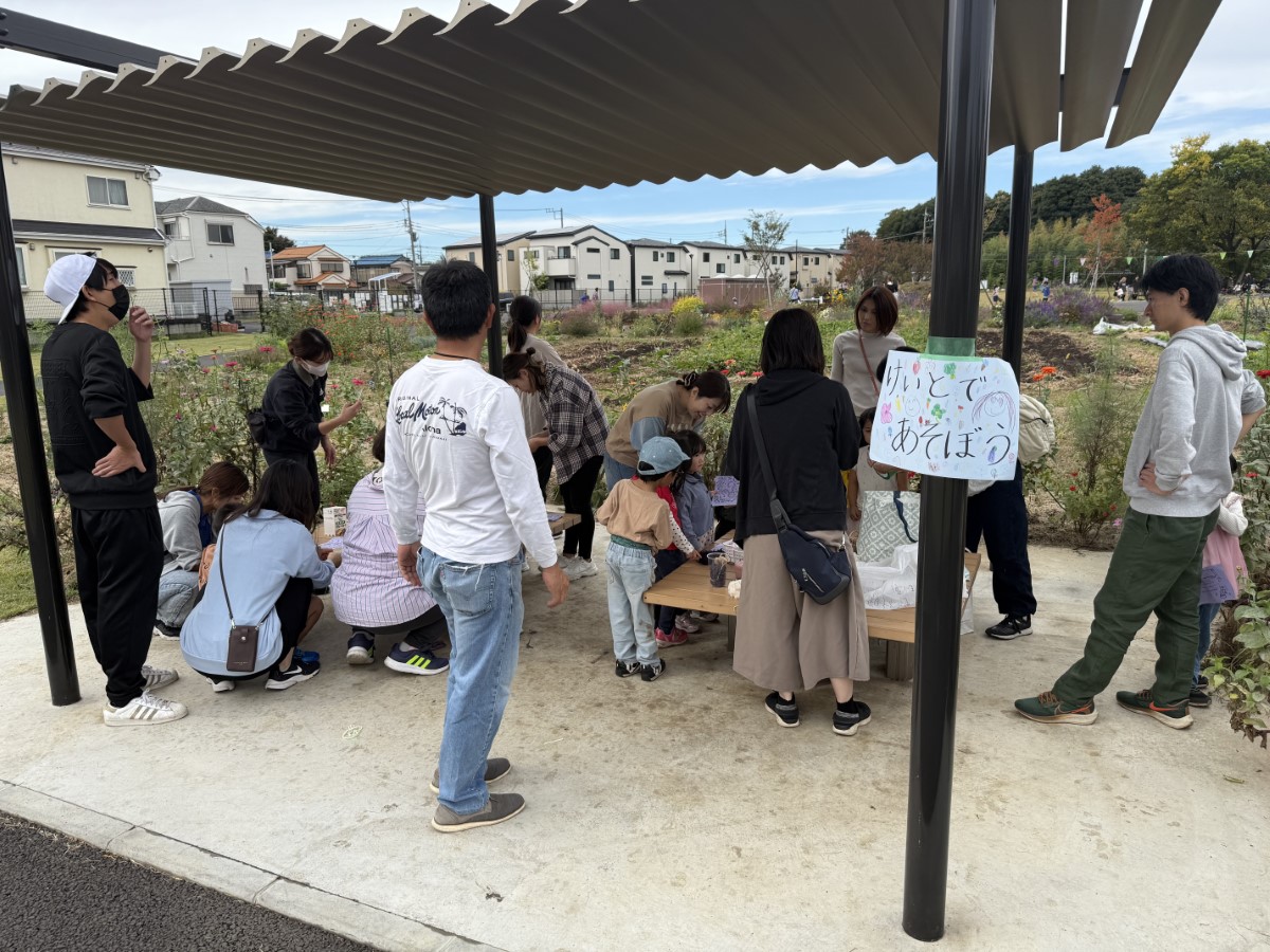屋根の下のベンチで毛糸で遊ぶ親子