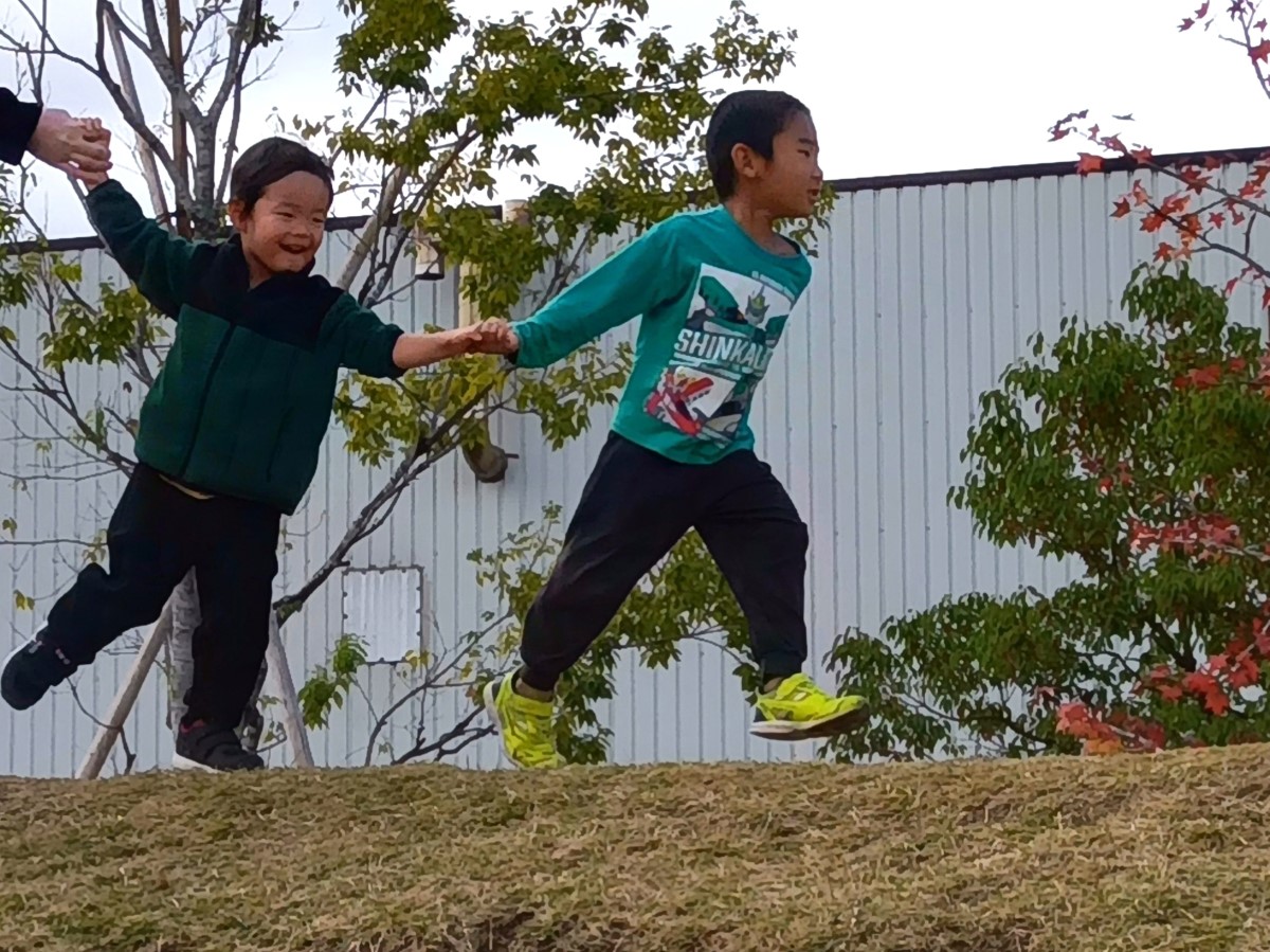 手をつないで走る子どもたち
