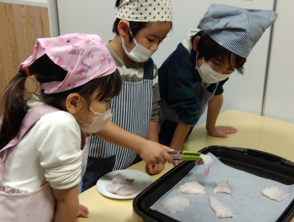 鯛の身をホットプレートに並べる子どもたち