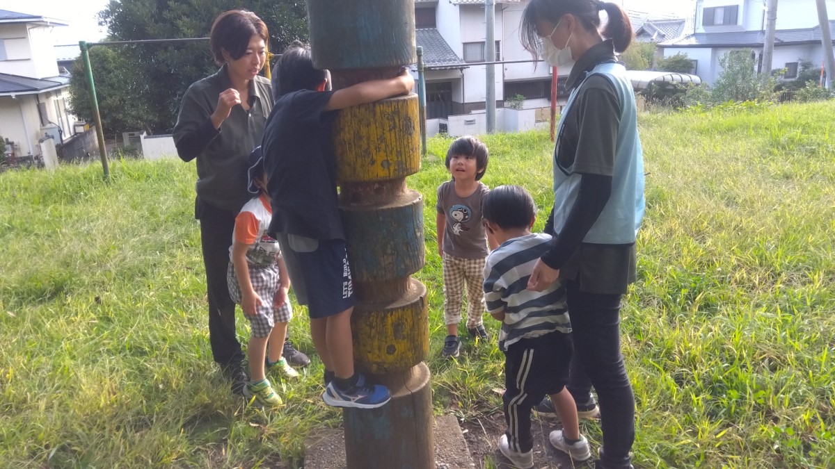順番でトーテムポールに登る子どもたち