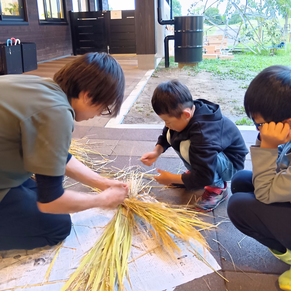 刈り取った稲を束ねる子ども