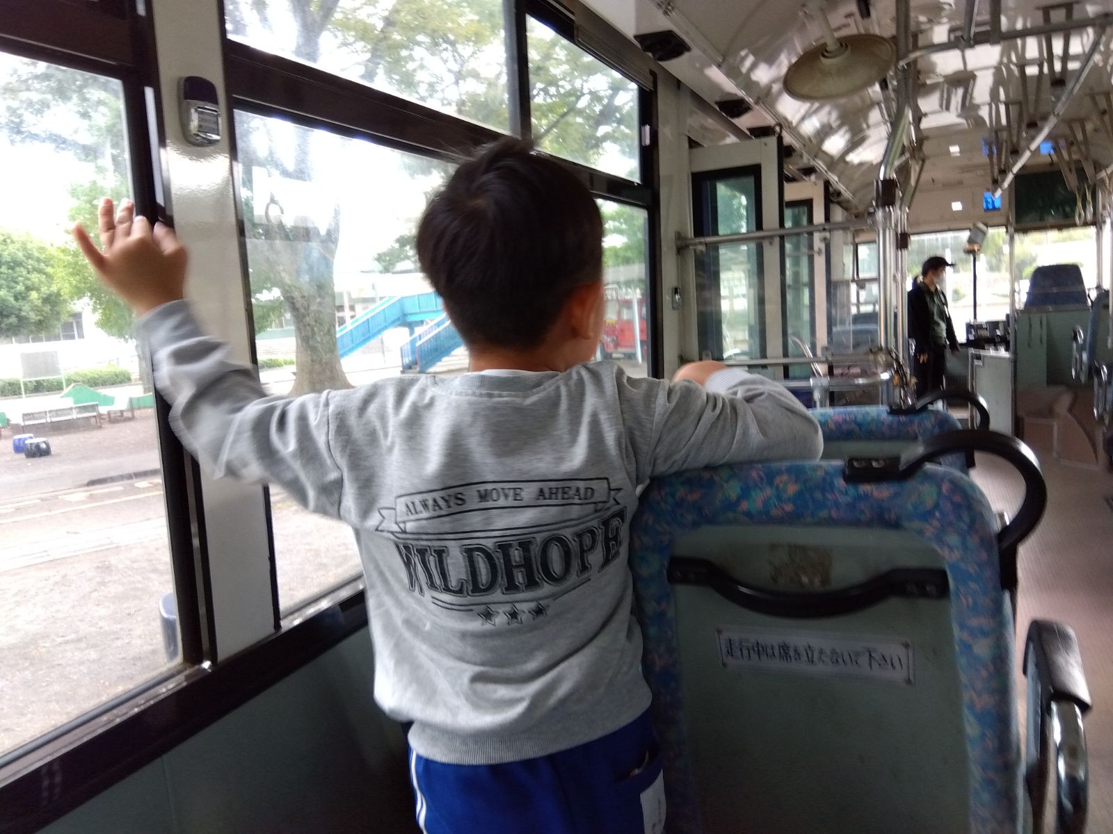 バスの座席に捕まる子ども