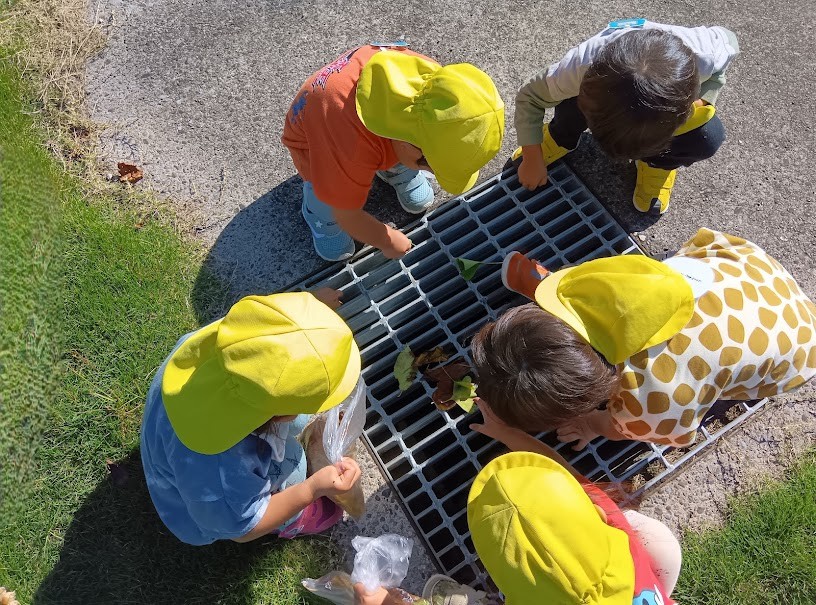 排水溝の中を覗き込む子どもたち