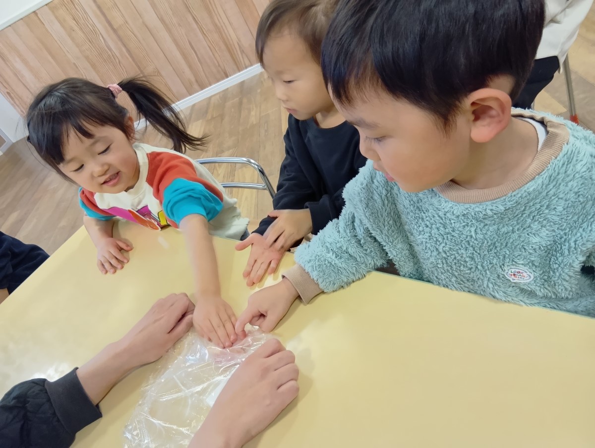 袋越しに鶏肉を触る子どもたち