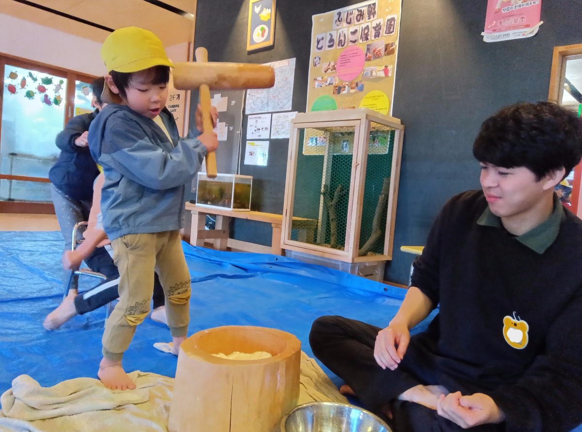 小さい杵で餅をつく子ども