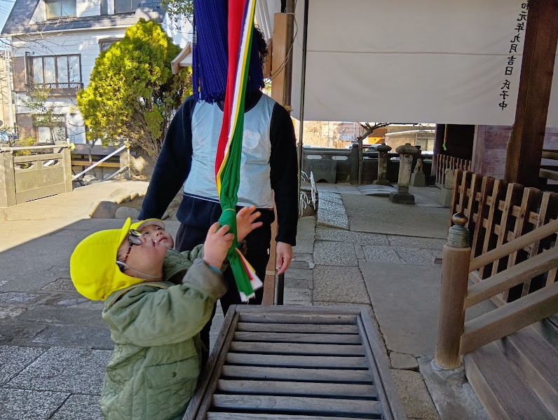 神社の鈴を鳴らす子どもたち