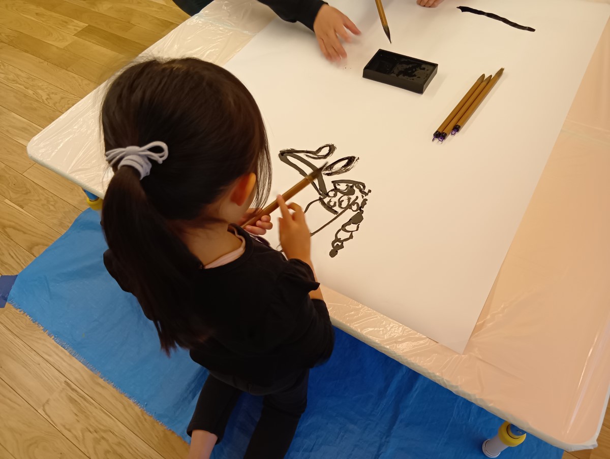 筆を使って絵を描く子ども