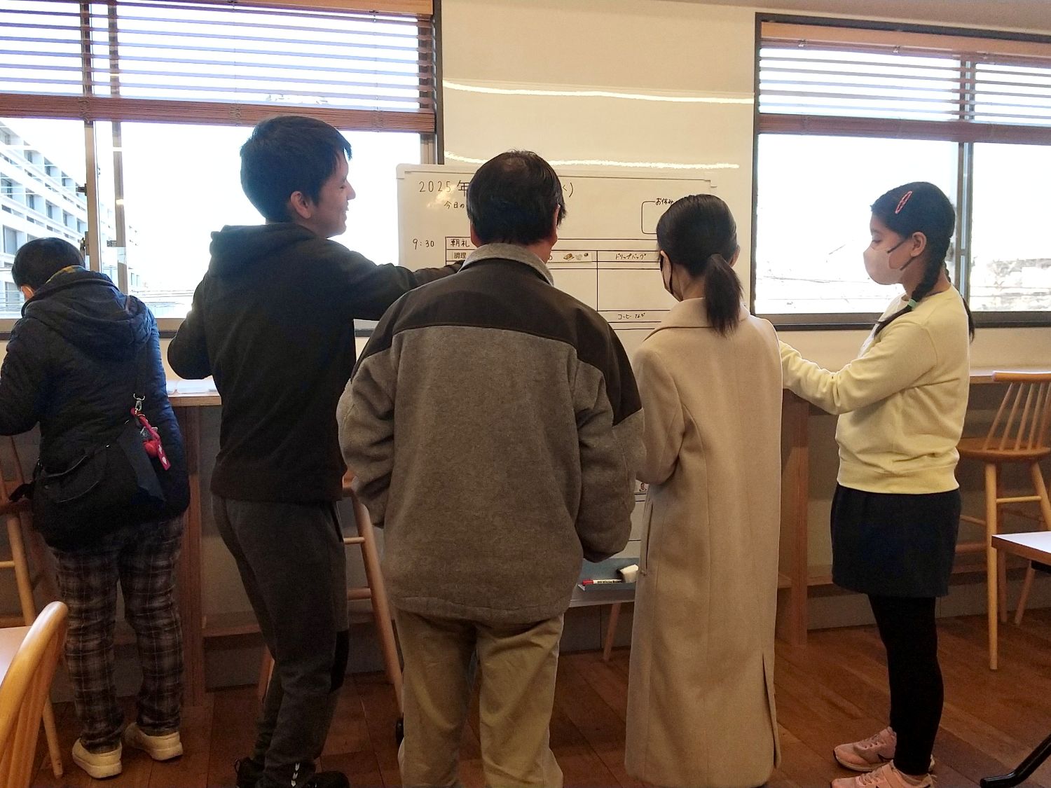 出勤後、ホワイトボードに名札を張り自ら業務内容を選択する様子