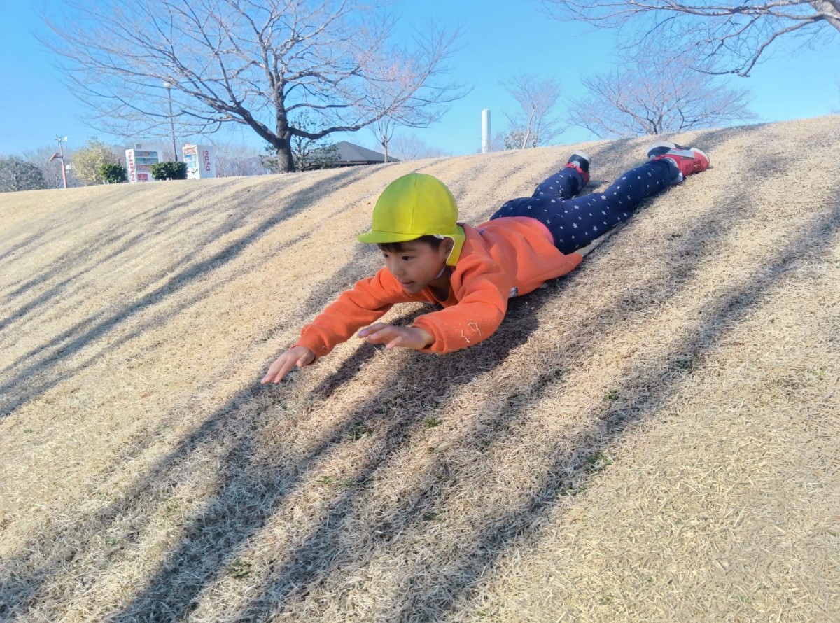斜面を滑り下りる子ども