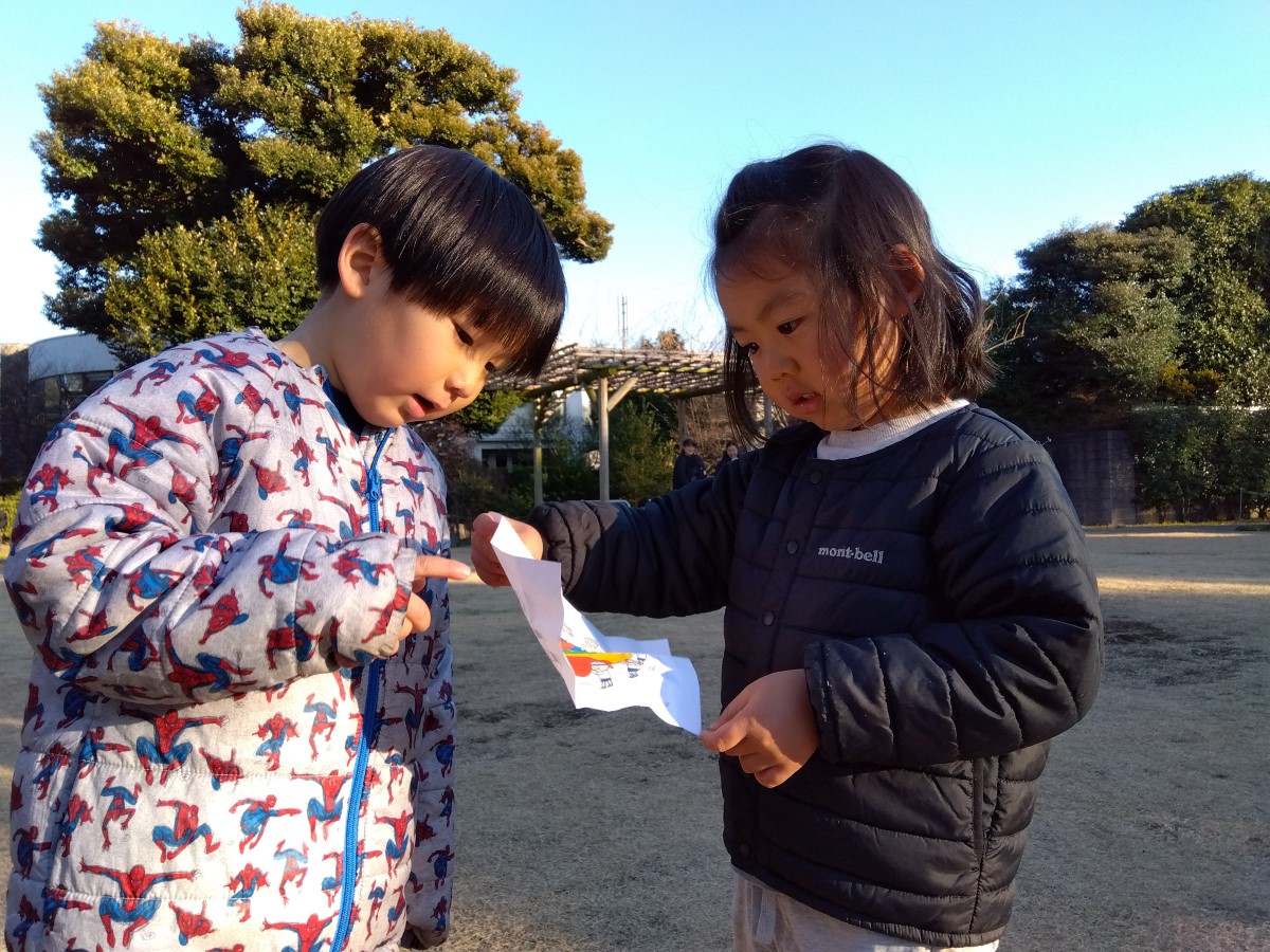 一緒に紙をのぞき込む子どもたち