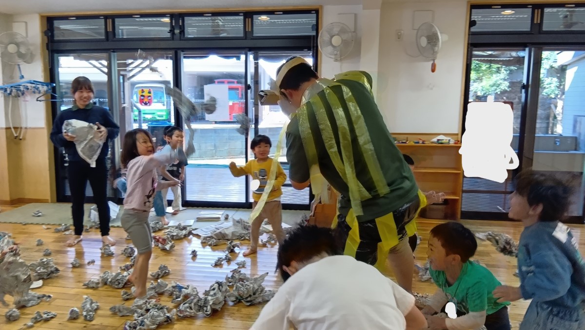 鬼に新聞紙を投げる子どもたち