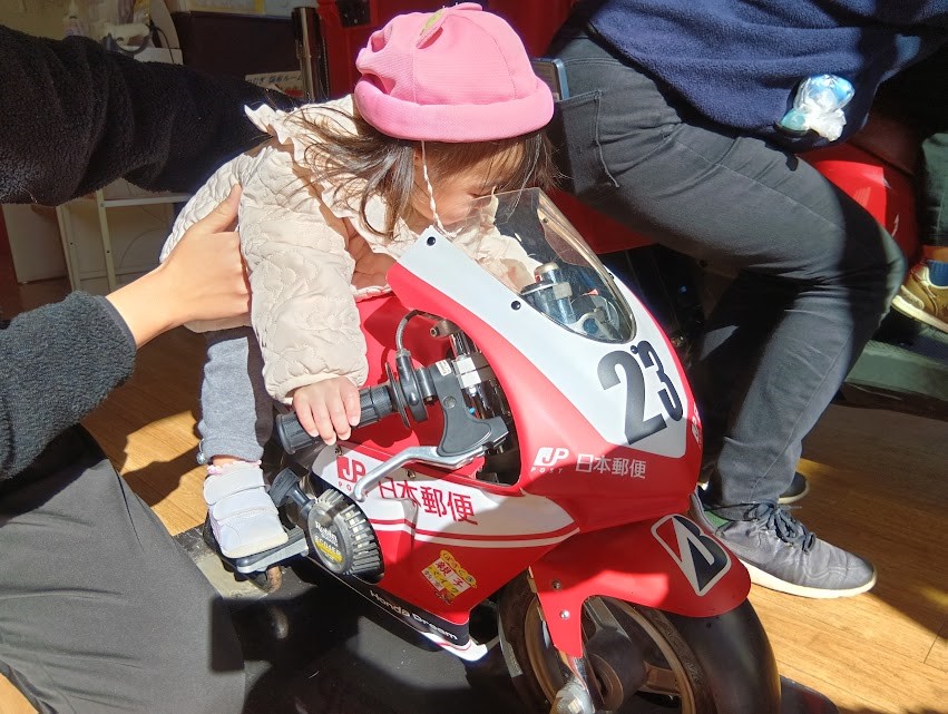 ポケットバイクに座らせてもらう子ども