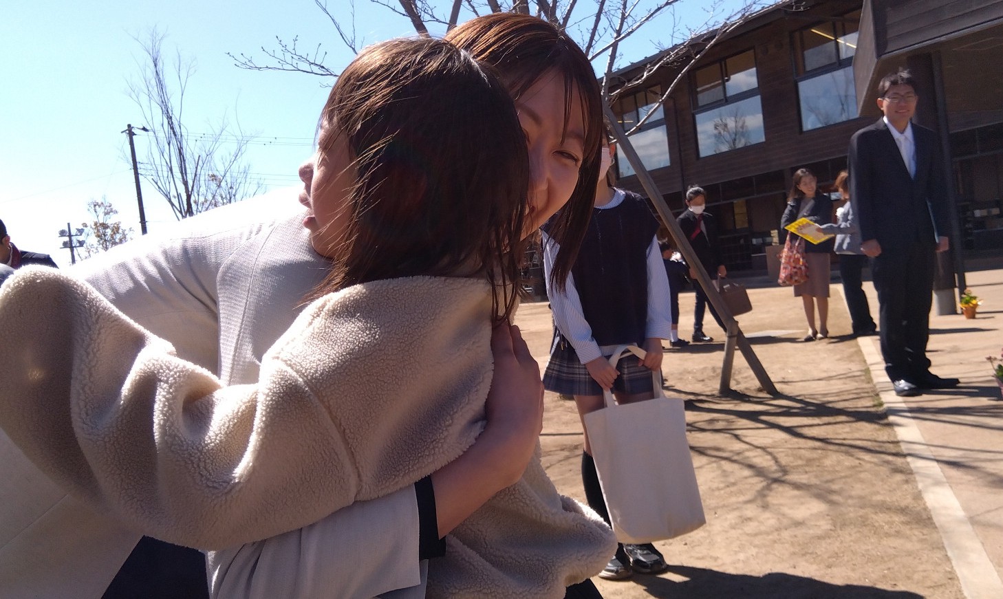子どもをハグする保護者