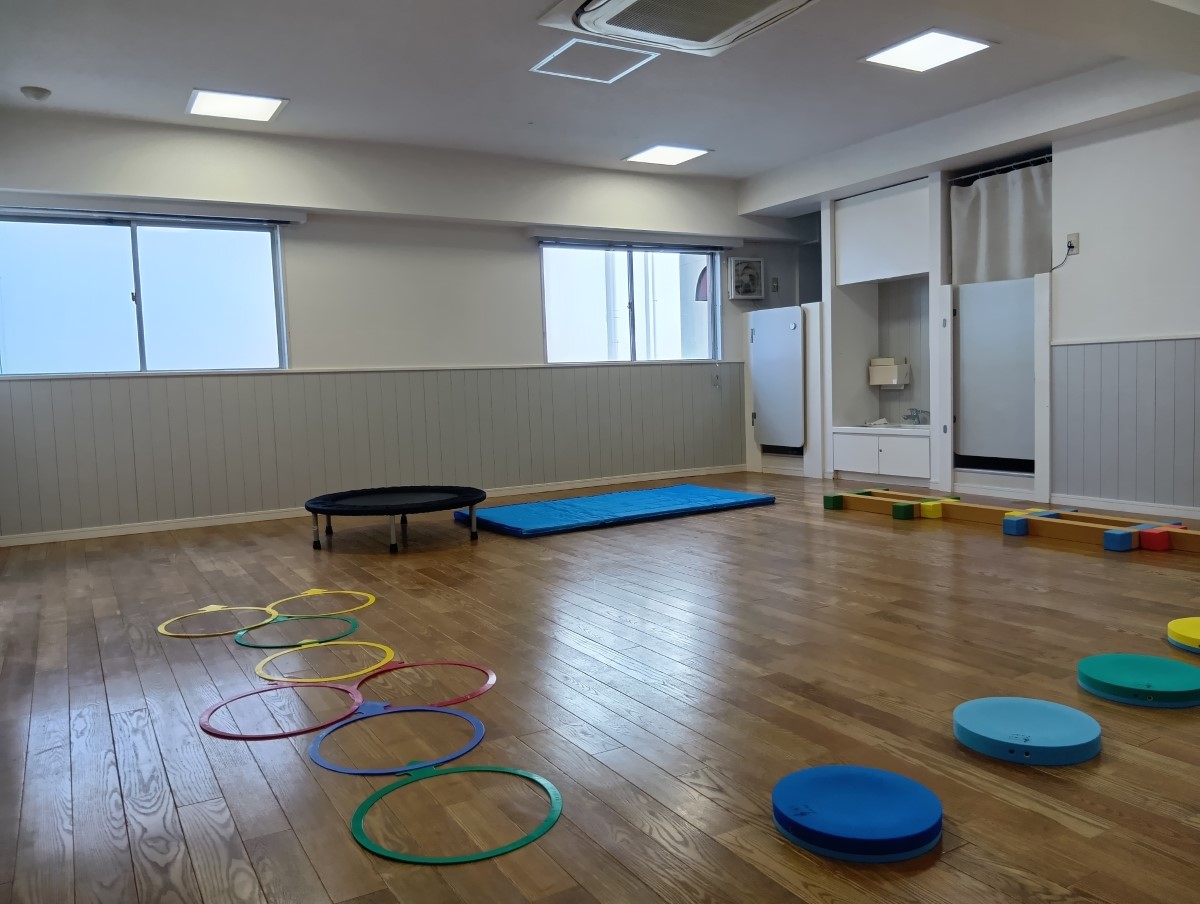 広い部屋にマットや平均台が置かれている、発達支援つむぎ 荻窪ルームの室内
