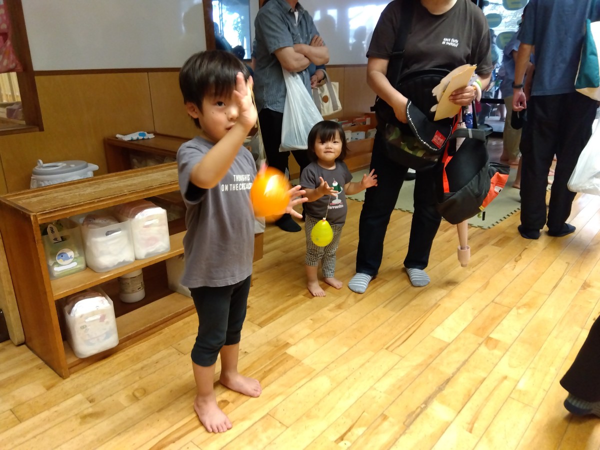 二人のこどもが手にヨーヨーを持ってこちらを見ている