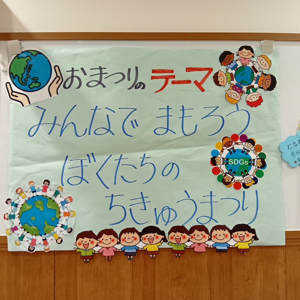 壁面には、祭りのテーマと地球と人のイラストが貼られている