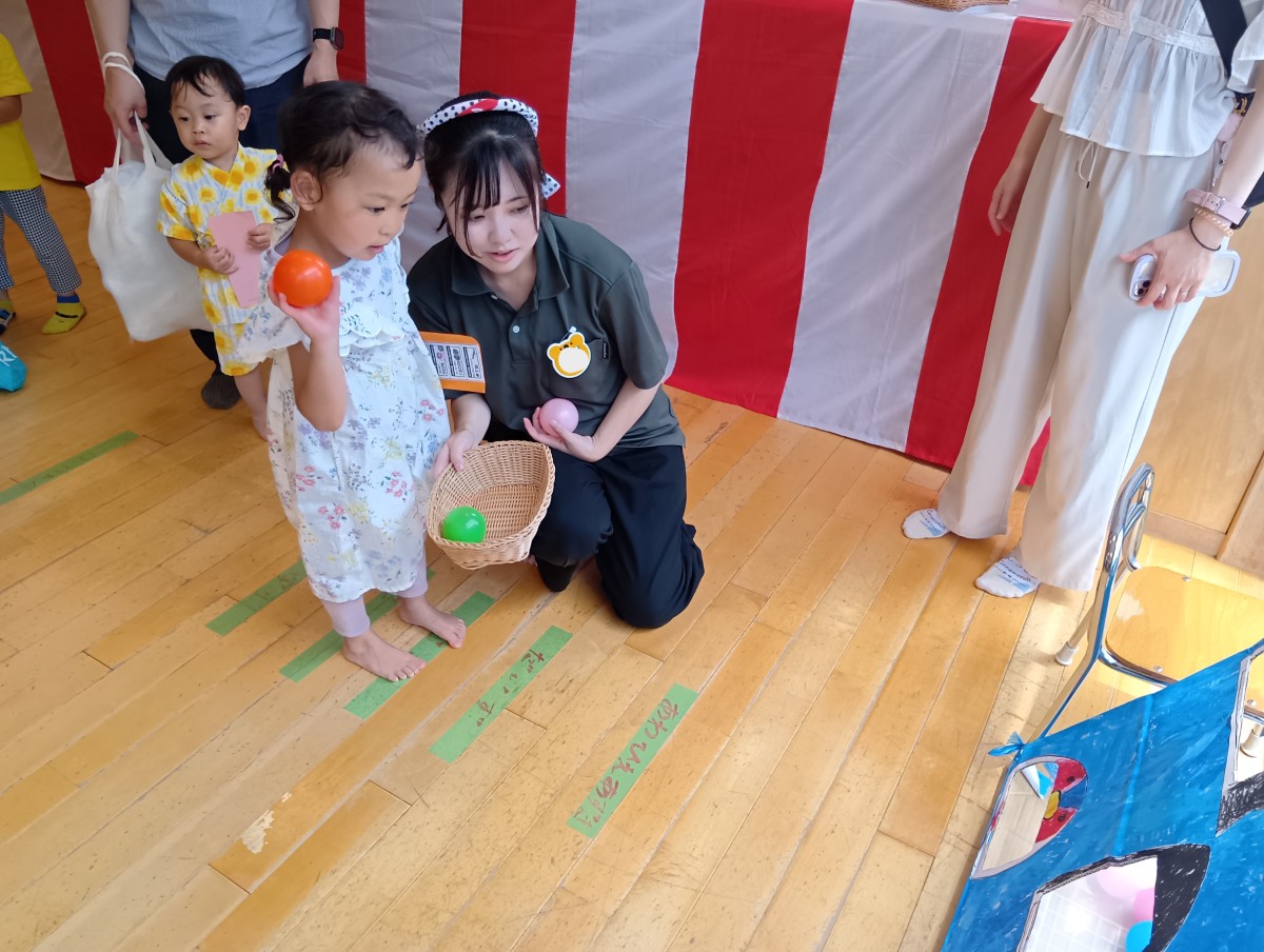 ボールを持った子ども線の上に立ち、的を目がけて投げようとしている