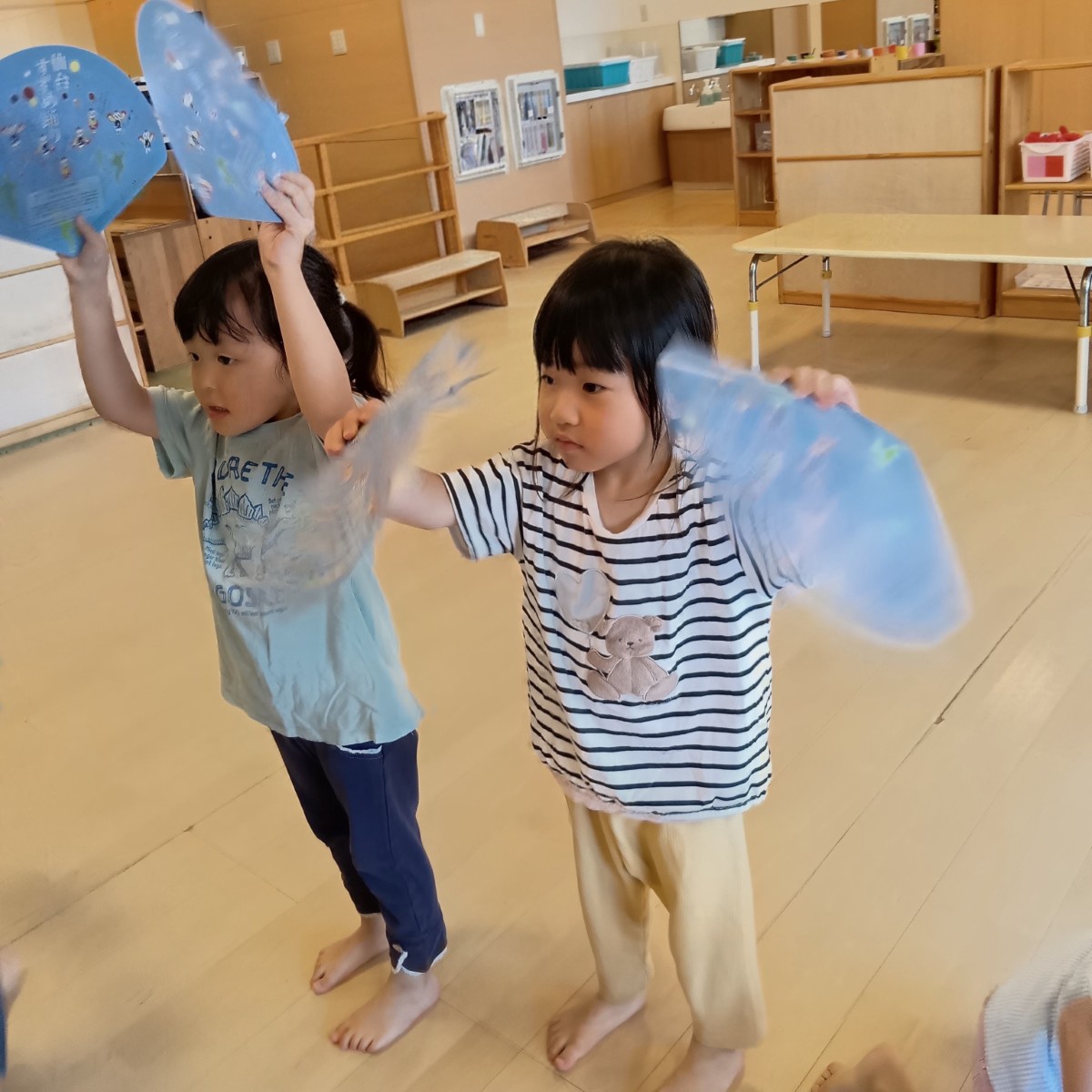 二人の子どもが扇子を持った両手を上にあげている