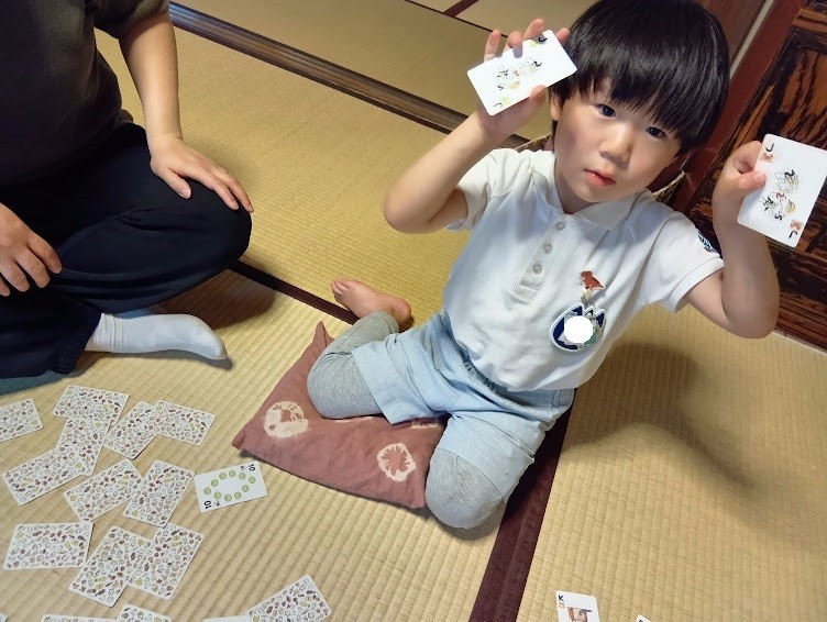 和室で一人の子どもがトランプで遊んでいる