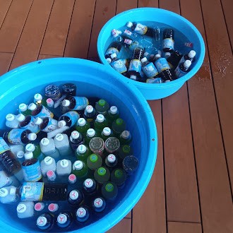 水の入った大小のたらいの中にはペットボトルがたくさん入っている