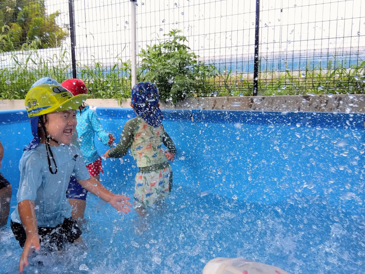 プールでは、水しぶきが顔にかかり喜ぶ子がいる