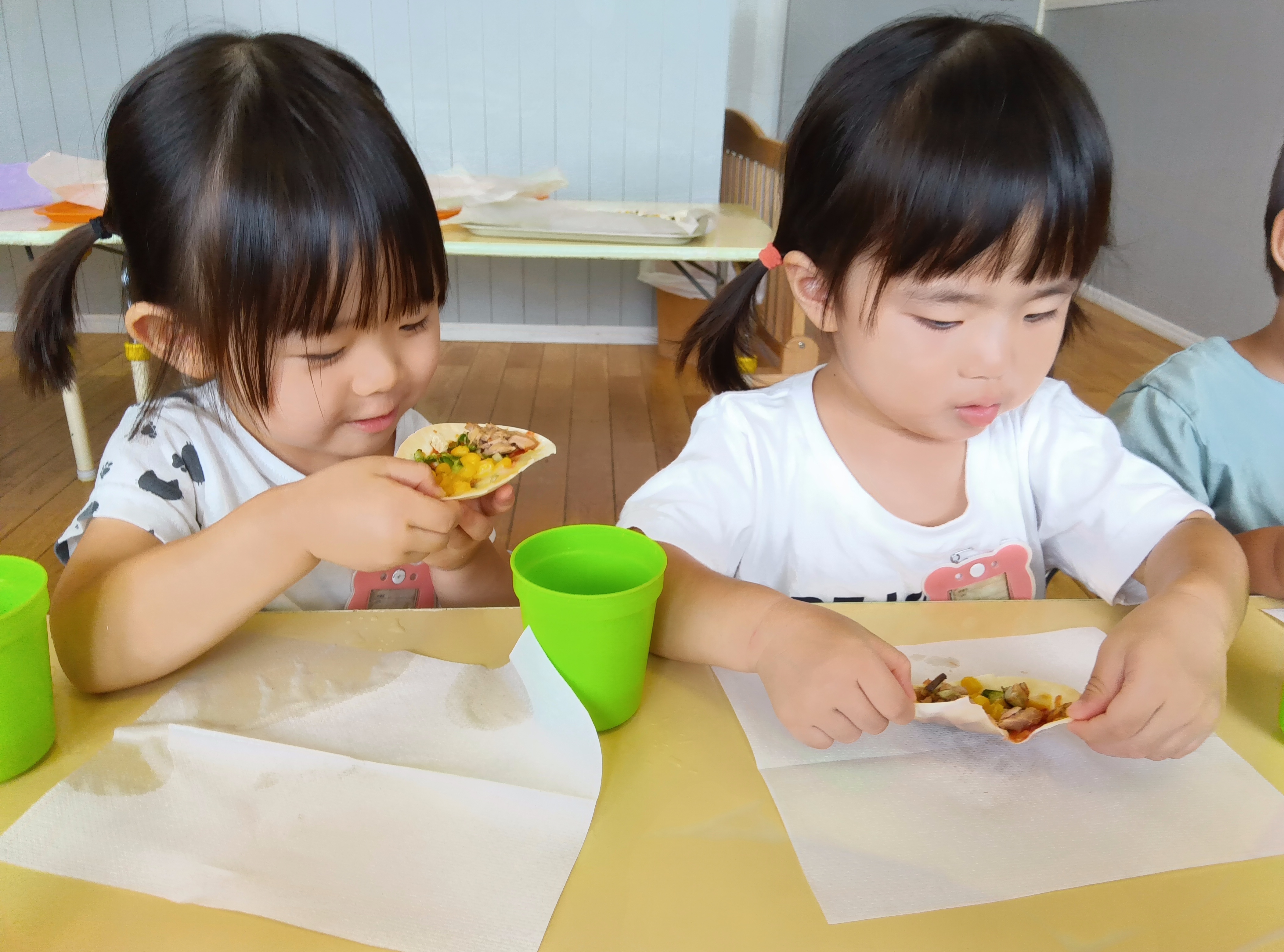子どもたちは、自ら作った餃子ピザを食べようとしている