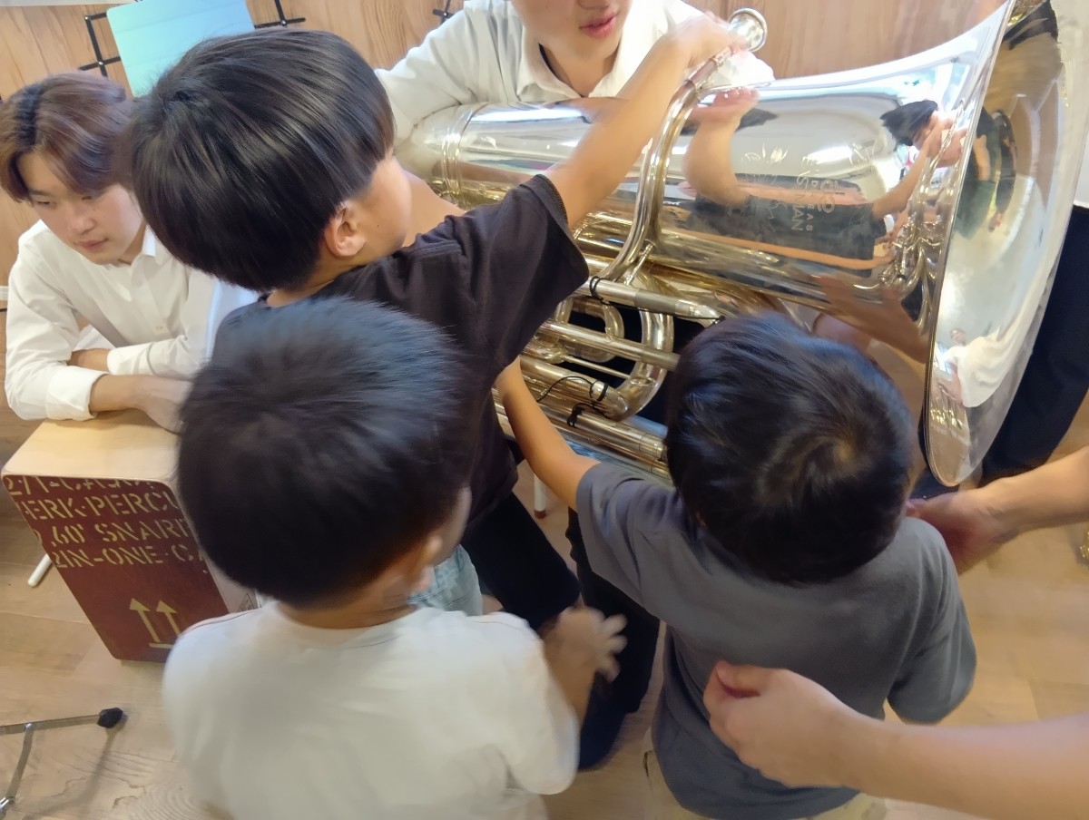 子どもたちが一つの楽器に集まり、楽器に触れている