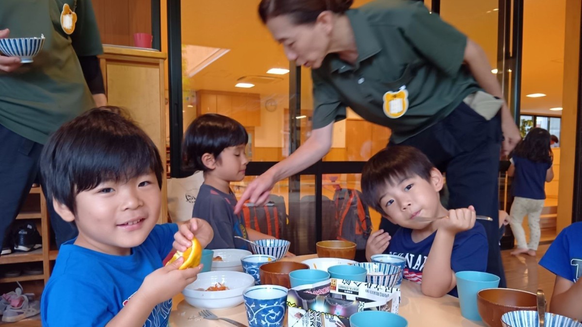 縁側で、子どもたちがご飯を食べている