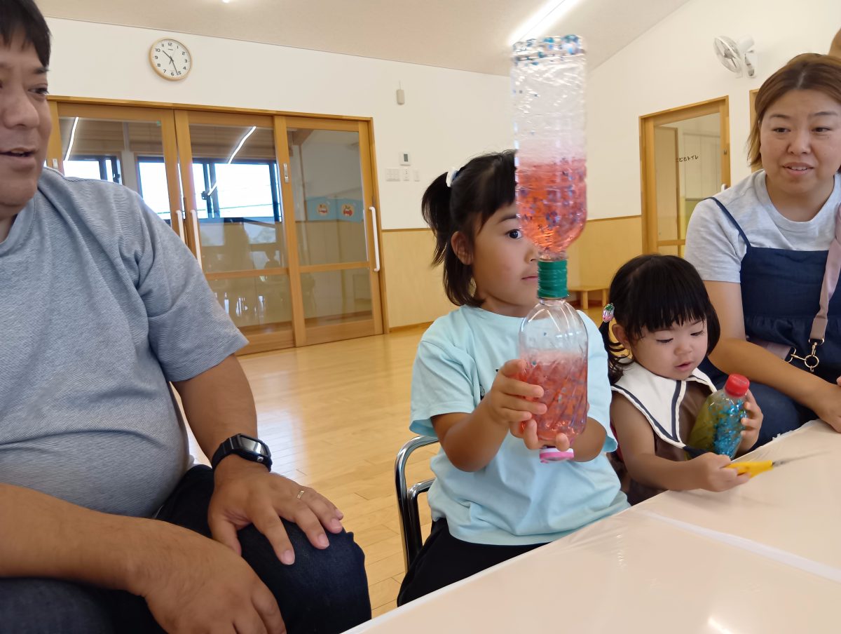 二人の子どもが出来上がった線センサリーボトルをじっと見つめている